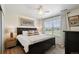 Cozy bedroom boasts a ceiling fan, a queen bed, decorative pillows, and natural light at 16188 Elizabeth St, Thornton, CO 80602