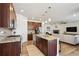Open kitchen concept with island, stainless appliances, and access to living room at 16188 Elizabeth St, Thornton, CO 80602