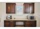 Butlers Pantry features a granite countertop, dark wood cabinets, and stainless steel appliances at 16188 Elizabeth St, Thornton, CO 80602