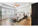 Well-lit primary bedroom showcases tray ceilings, a ceiling fan, and a plush king bed at 16188 Elizabeth St, Thornton, CO 80602