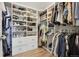 Organized walk-in closet featuring custom shelving, hanging rods, and ample storage space at 16188 Elizabeth St, Thornton, CO 80602