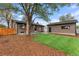 Well-kept backyard features grass, mulch, and a brick house with a detached garage at 4580 Garland St, Wheat Ridge, CO 80033