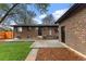 Brick home and detached garage show the backyard with grass, mulch, and a stone pathway at 4580 Garland St, Wheat Ridge, CO 80033