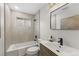 Stylish bathroom featuring a modern vanity, neutral tiling, and a shower-tub combo at 4580 Garland St, Wheat Ridge, CO 80033