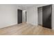 Bright bedroom with minimalist decor featuring modern flooring and closet with black doors at 4580 Garland St, Wheat Ridge, CO 80033