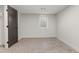 A cozy, carpeted room features a window and a dark colored interior door at 4580 Garland St, Wheat Ridge, CO 80033