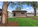A brick detached garage features a small window and black door framed by green grass and mulch at 4580 Garland St, Wheat Ridge, CO 80033