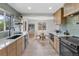 Open kitchen featuring sleek appliances, a tile backsplash, and an adjacent dining area at 4580 Garland St, Wheat Ridge, CO 80033