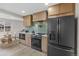 Well-lit kitchen with wood cabinets, a breakfast nook, and a modern black refrigerator at 4580 Garland St, Wheat Ridge, CO 80033