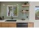 Modern kitchen sink with elegant marble countertops, a black faucet, and stylish green tile backsplash at 4580 Garland St, Wheat Ridge, CO 80033