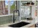 Close-up of a modern kitchen sink featuring a black faucet and a window view at 4580 Garland St, Wheat Ridge, CO 80033