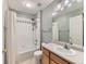 Clean bathroom with a shower-tub combo, white tile, and wood vanity at 11851 Elm Dr, Thornton, CO 80233