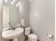 Cozy bathroom features a pedestal sink, toilet, and neutral gray walls at 11851 Elm Dr, Thornton, CO 80233