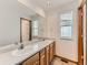 Bathroom featuring a dual sink vanity with wood cabinets, a large mirror, and neutral paint at 11851 Elm Dr, Thornton, CO 80233