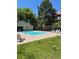 Community pool and deck with lounge chairs surrounded by mature trees and green grass at 14751 E Tennessee Dr # 222, Aurora, CO 80012