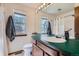 Bathroom featuring a large mirror, green countertops, and a window providing natural light at 9957 Grove Way # F, Westminster, CO 80031