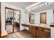 Bathroom featuring tiled vanity with a large mirror and double closets at 9957 Grove Way # F, Westminster, CO 80031