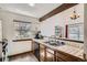 Charming kitchen featuring tile counters, wood cabinets, and a sunny window overlooking the outdoor landscape at 9957 Grove Way # F, Westminster, CO 80031