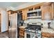 Close-up of kitchen appliances including a stainless steel refrigerator, gas range oven, and a built-in microwave at 9957 Grove Way # F, Westminster, CO 80031
