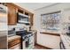 Kitchen showcasing stainless steel oven, microwave and tile countertops next to a sunlit window at 9957 Grove Way # F, Westminster, CO 80031