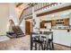 Inviting living area with wood floors, staircase, and open layout to the kitchen featuring a high-top table with chairs at 9957 Grove Way # F, Westminster, CO 80031