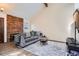 Cozy living room featuring a decorative brick fireplace, a gray sofa, and a vaulted ceiling at 9957 Grove Way # F, Westminster, CO 80031