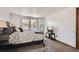 Spacious main bedroom featuring neutral carpet, large windows, a television and a queen-sized bed at 9957 Grove Way # F, Westminster, CO 80031