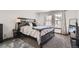Main bedroom featuring neutral carpet, large windows and a queen-sized bed with decorative pillows and a gray comforter at 9957 Grove Way # F, Westminster, CO 80031