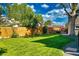 Expansive backyard features a green lawn, privacy fence, mature trees, and an inviting patio area at 1750 E Noble Pl, Centennial, CO 80121