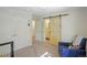 Bright bedroom with hardwood floors, barn door leading to an en-suite bathroom, and a comfortable chair at 1750 E Noble Pl, Centennial, CO 80121
