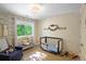 Charming bedroom with crib, accent wall, and a window offering a view of lush greenery at 1750 E Noble Pl, Centennial, CO 80121