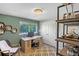 Cozy home office with a wood desk, decorative shelves, and natural light from the window at 1750 E Noble Pl, Centennial, CO 80121