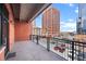 Private balcony with black iron railing offers an urban view of the neighborhood buildings at 1800 Lawrence St # 303, Denver, CO 80202
