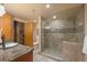 Bathroom featuring modern glass shower, stylish vanity, and neutral tile flooring at 1800 Lawrence St # 303, Denver, CO 80202