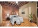 Cozy bedroom with exposed brick wall, hardwood floors, and stylish decor at 1800 Lawrence St # 303, Denver, CO 80202