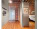 Welcoming entryway with hardwood floors, exposed brick, and convenient coat rack next to metal front door at 1800 Lawrence St # 303, Denver, CO 80202