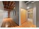 Hallway featuring exposed brick and hardwood floors at 1800 Lawrence St # 303, Denver, CO 80202