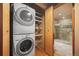 A closet with a stacked washer and dryer next to shelving and a bathroom at 1800 Lawrence St # 303, Denver, CO 80202