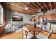 Open-concept living space with exposed wood ceilings, modern furnishings, and abundant natural light at 1800 Lawrence St # 303, Denver, CO 80202