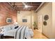 A spacious bedroom with exposed brick wall, hardwood floors, and a cozy interior design at 1800 Lawrence St # 303, Denver, CO 80202