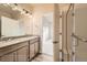 Bright bathroom showcasing a glass-enclosed shower and double vanity, leading into a well-lit bedroom at 844 W 128Th Pl, Westminster, CO 80234