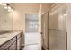 Bathroom view featuring a glass-enclosed shower and double vanity, leading into a light filled bedroom at 844 W 128Th Pl, Westminster, CO 80234