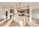 Open kitchen with island, modern appliances, tile backsplash, and wood-style flooring at 844 W 128Th Pl, Westminster, CO 80234