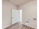 Bright laundry room features wood-look flooring, washer/dryer hookups, and an open doorway at 844 W 128Th Pl, Westminster, CO 80234
