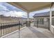 Covered patio with black metal railing, stone pillars, and views of the surrounding landscape at 844 W 128Th Pl, Westminster, CO 80234