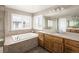 Bright bathroom with double vanity, large mirror, a soaking tub and plentiful natural light at 13507 W 87Th Ter, Arvada, CO 80005