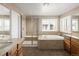 The bathroom features a separate glass shower and soaking tub underneath a bright window at 13507 W 87Th Ter, Arvada, CO 80005