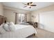 Bright bedroom featuring a ceiling fan, desk area, and plush bedding at 13507 W 87Th Ter, Arvada, CO 80005