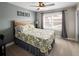 A carpeted bedroom features a bright window with curtains, ceiling fan and queen-sized bed at 13507 W 87Th Ter, Arvada, CO 80005