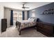 The bedroom features a vibrant blue accent wall, ceiling fan and bright, sunny window at 13507 W 87Th Ter, Arvada, CO 80005